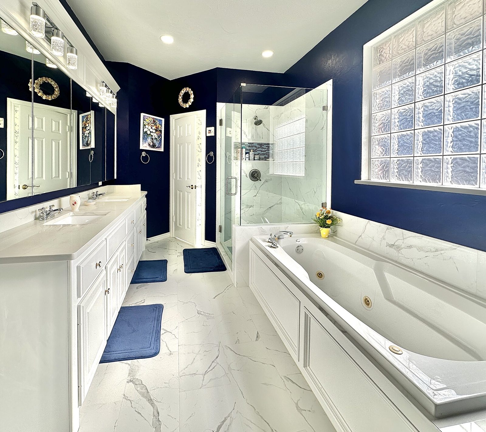 Bathroom with navy walls, marble tile and glass shower (stock inspiration photo)